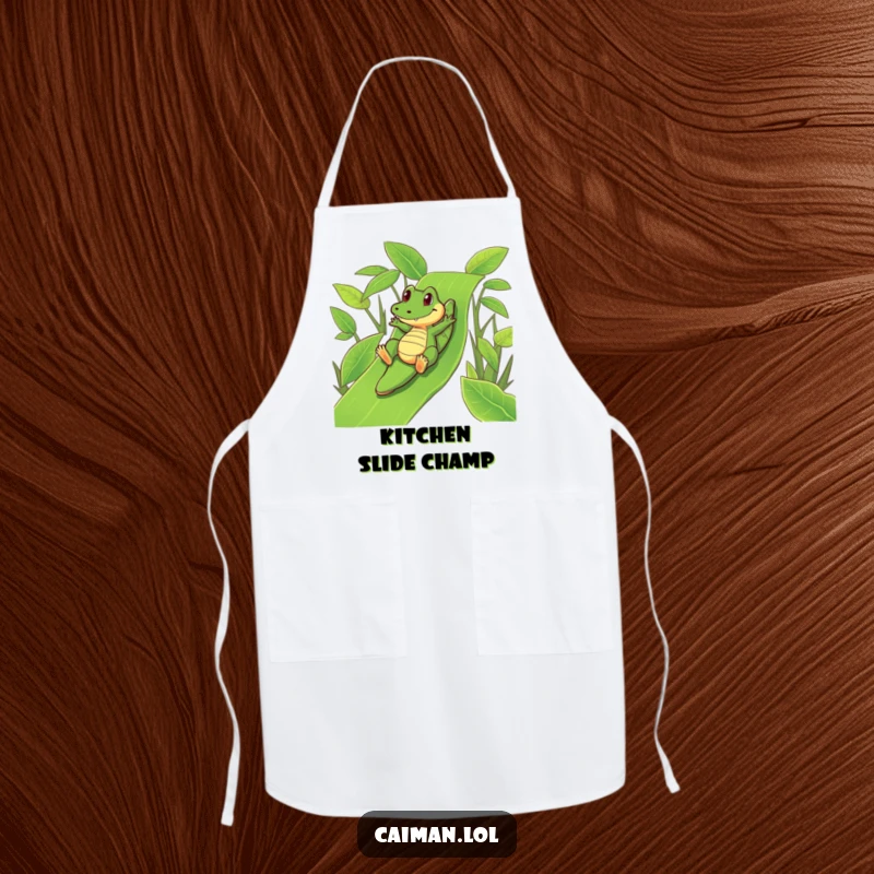 Funny Caiman Apron: A humorous cooking apron showing a funny caiman playfully sliding down a vibrant, green leafy slide.