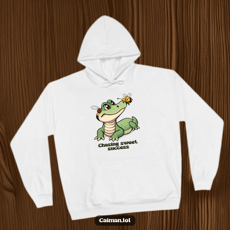 Funny Caiman Hoodie, a warm and cozy garment featuring a curious caiman observing a colorful, buzzing bee in a humorous outdoor scene.