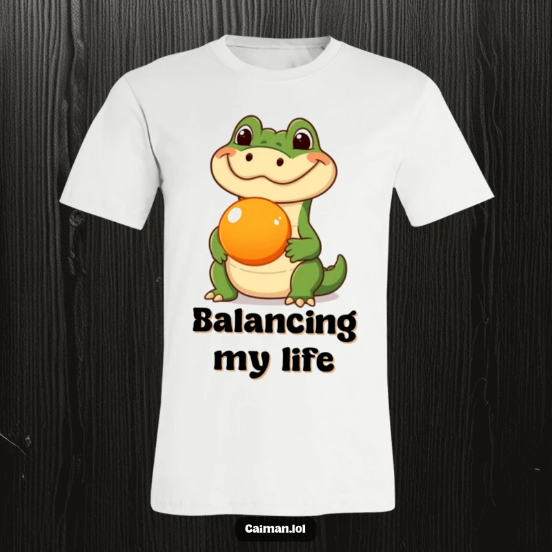 Funny Caiman T-Shirt, a humorous graphic of a caiman with a silly expression, skillfully balancing a round orange fruit on its snout.