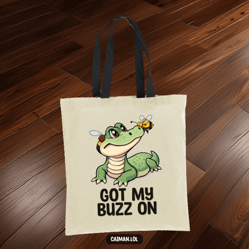 Funny Caiman Tote Bag, a reusable bag showcasing a curious caiman intently following a small, buzzing bee, perfect for humorous shopping.